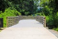 A long winding boardwalk along the river with a wooden rail along the sides with vast still river water, lush green trees Royalty Free Stock Photo