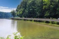 A long winding boardwalk along the river with a wooden rail along the sides with vast still river water, lush green trees Royalty Free Stock Photo