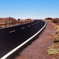 Long winding curve in an black empty road Royalty Free Stock Photo