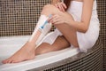 Long Woman Legs . Woman Shaving Legs in Bathroom Royalty Free Stock Photo