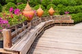 Long wooden bench decorative with big pottery pot on flower garden background