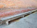 Long wooden benches along a brick wall Royalty Free Stock Photo