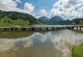 Long wooden boardwalk on a calm and placid mountain lake with a great view