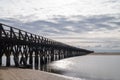 Long wooden boardwalk pier leads from one beach to another over a small ocean inlet Royalty Free Stock Photo