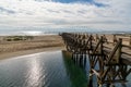 Long wooden boardwalk pier leads from one beach to another over a small ocean inlet Royalty Free Stock Photo