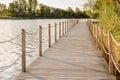 Long Wooden bridge over lake. Beautiful sunrise over lake pier. Planked footway on the river or lake Royalty Free Stock Photo