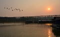 Long wooden bridge over the river in the evening