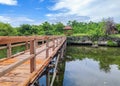 A long wooden bridge over a water pool on a sunny day Royalty Free Stock Photo