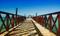 Long wooden dock with fence, stretching into the sea Royalty Free Stock Photo