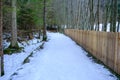 a long wooden fence separates the property area. the winter tourism trail goes along the fenced off property Royalty Free Stock Photo