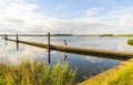 Long wooden jetty in a lake with a mirror smooth surface Royalty Free Stock Photo