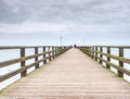 Long wooden pier on Baltic coast during morning calm. Cold weather, silent day