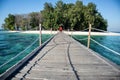 Long wooden pier (bridge) extents from beach at karang panambungan Island Royalty Free Stock Photo