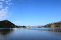 A long wooden pier on a deep blue sea in a small bay Royalty Free Stock Photo