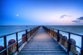 Long wooden pier extends over water toward the horizon. A leading line to the horizone Royalty Free Stock Photo