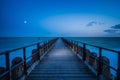 Long wooden pier extends over water toward the horizon. A leading line to the horizone Royalty Free Stock Photo