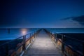 Long wooden pier extends over water toward the horizon. A leading line to the horizone Royalty Free Stock Photo
