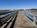 The wooden pier looking inwards at at Murrell\'s Inlet, south of Myrtle Beach, South Carolina, USA, on a sunny day with blue Royalty Free Stock Photo