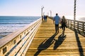 A long wooden pier, and walking people. Cayucos pier, California Central coast