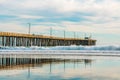 A long wooden rustic pier at sunset. Beautiful Pacific ocean, and beautiful cloudy sky in the background, Avila beach, California Royalty Free Stock Photo