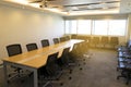 Long wooden table and a lot of chair in big meeting room with projector presentation sunlight from window Royalty Free Stock Photo