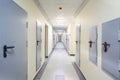 Long yellow hallway with grey metal doors and floor