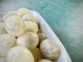 Peeled fresh longan in a white bowl on a green background. Close up select focus. Royalty Free Stock Photo