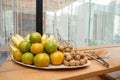 Longan, orange, banana fruit set in bamboo plate on the table in the outdoor field Royalty Free Stock Photo