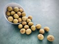 Longan poured out in a white bowl. on green background. Royalty Free Stock Photo