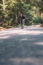 Longboard skating - Skateboarder ride a longboard through the forest