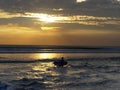 Longboard surfer walks out to go surfing at sunset on kuta beach, bali