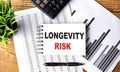 LONGEVITY RISK text on a notebook with chart and calculator Royalty Free Stock Photo