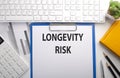 LONGEVITY RISK written on the paper with keyboard, chart, calculator and notebook Royalty Free Stock Photo