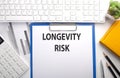 LONGEVITY RISK written on paper with keyboard, chart, calculator and notebook Royalty Free Stock Photo