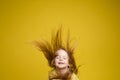 Longhaired girl in cute shirt playing with hair and twirling