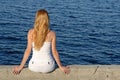 Longhaired girl sitting by the sea