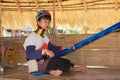 LONGNECK KAREN VILLAGE, THAILAND - DECEMBER 17. 2017: Long neck woman doing handwork under thatched roof