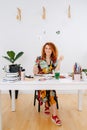 Longshot of happy artist woman painting behind work desk with a brush Royalty Free Stock Photo