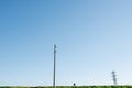 Longshot of a man riding bike along powerlines. Over blue sky Royalty Free Stock Photo