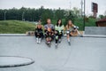 Longshot portrait of a group of skaters chilling on the deck at skatepark