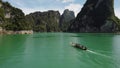 Longtail boat crusing towards cliffs in the distance in Surathani, Thailand