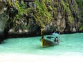 Longtale boats at the Phuket beach with limestone rock on background in Thailand. Phuket island is a most popular tourist destinat