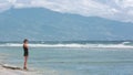 Lonley woman standing on ocean coast look on waves