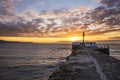 Looe beach and pier at sunrise .