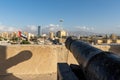 Looing out from top of Ras al Khaimah Museum fort look out from canon to the city, UAE flag and Hajar Mountains Royalty Free Stock Photo