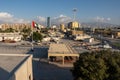 Looing out from top of Ras al Khaimah Museum fort look out to the city, UAE flag and Hajar Mountains on a sunny day with a few