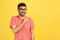 Look at advertise! Positive bearded man in striped t-shirt pointing finger away at empty space for your advertisement, looking at Royalty Free Stock Photo