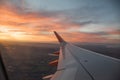 Look on the aerplane wing with orange, red and blue cloudy sky. Royalty Free Stock Photo