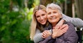 They look alike. a cheerful elderly woman in a wheelchair spending time with her daughter outside in a park. Royalty Free Stock Photo