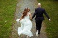 A look from behind on the running wedding couple Royalty Free Stock Photo